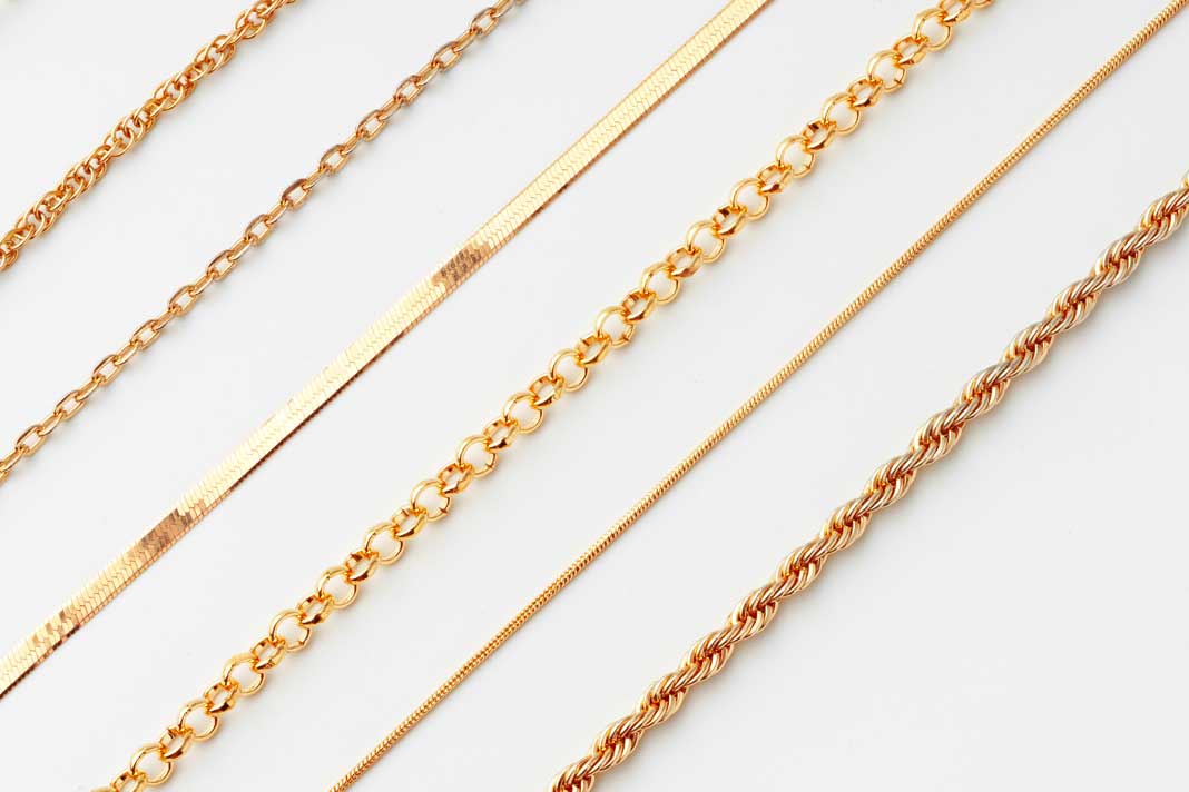 jewelry-set-of-golden-chains-on-the-white-backgrou-ngcw