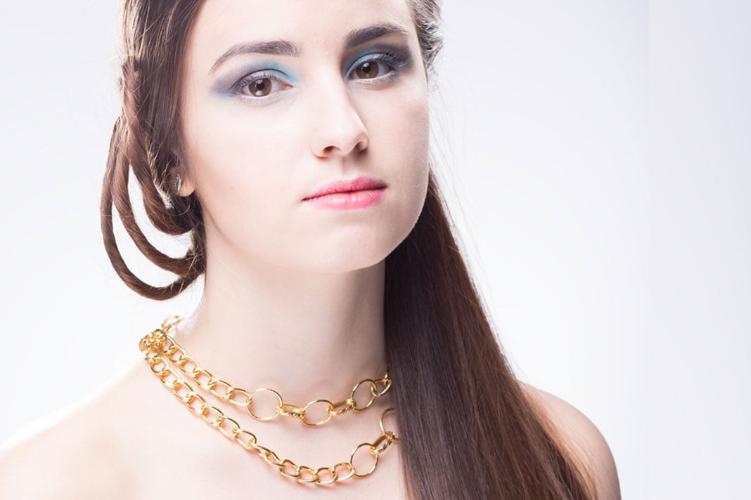 portrait-of-a-beautiful-young-woman-looking-at-the-gold-chains-for-women-ngcw